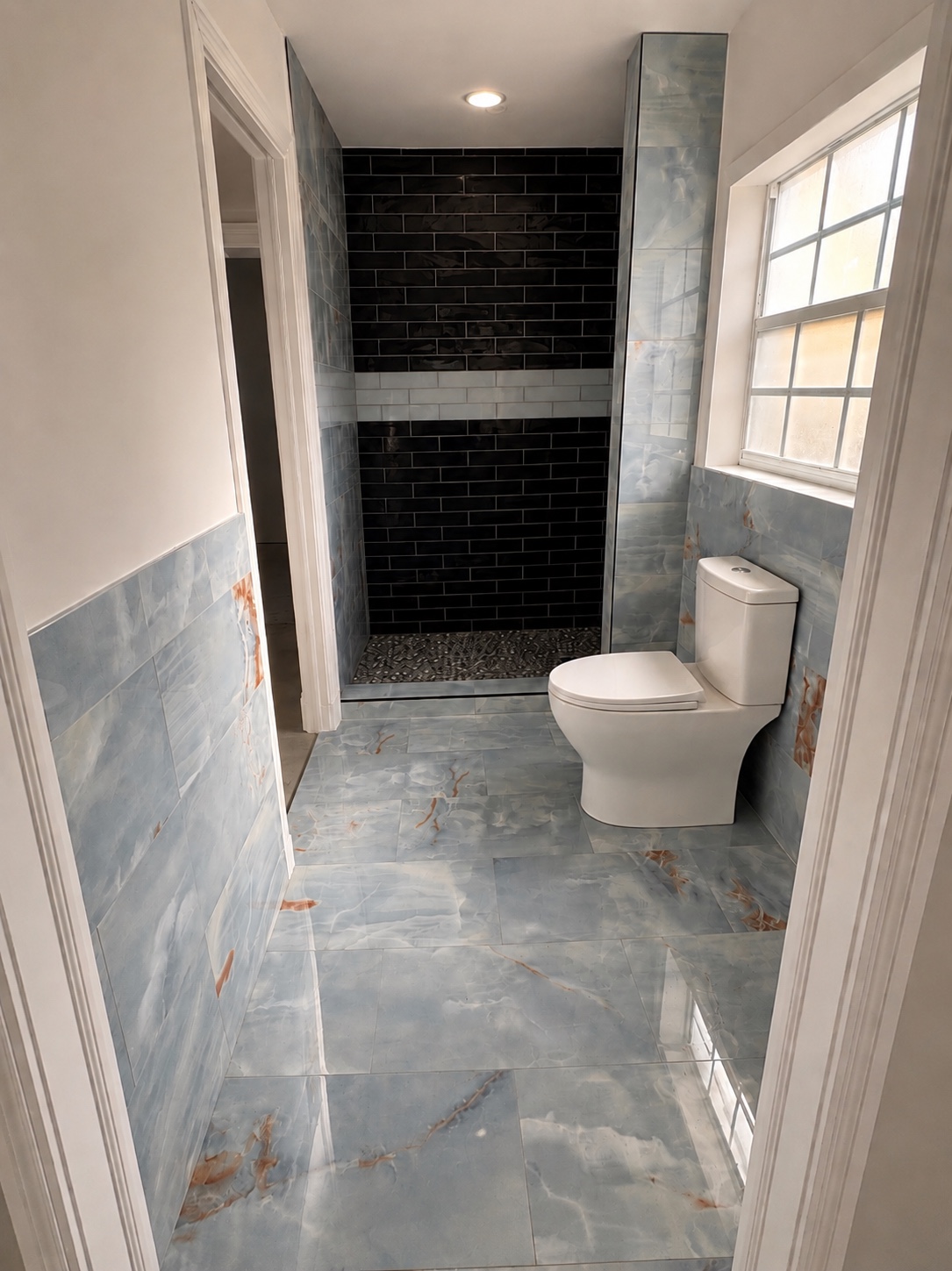 Baño con tile azul brillante y ducha con pared negra