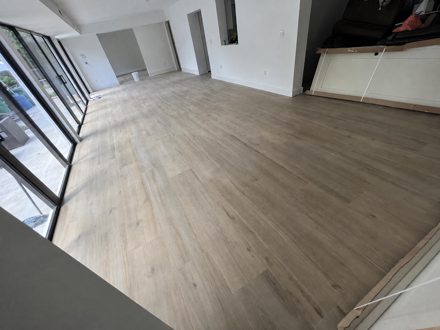 Piso de apariencia madera clara junto a puertas de cristal