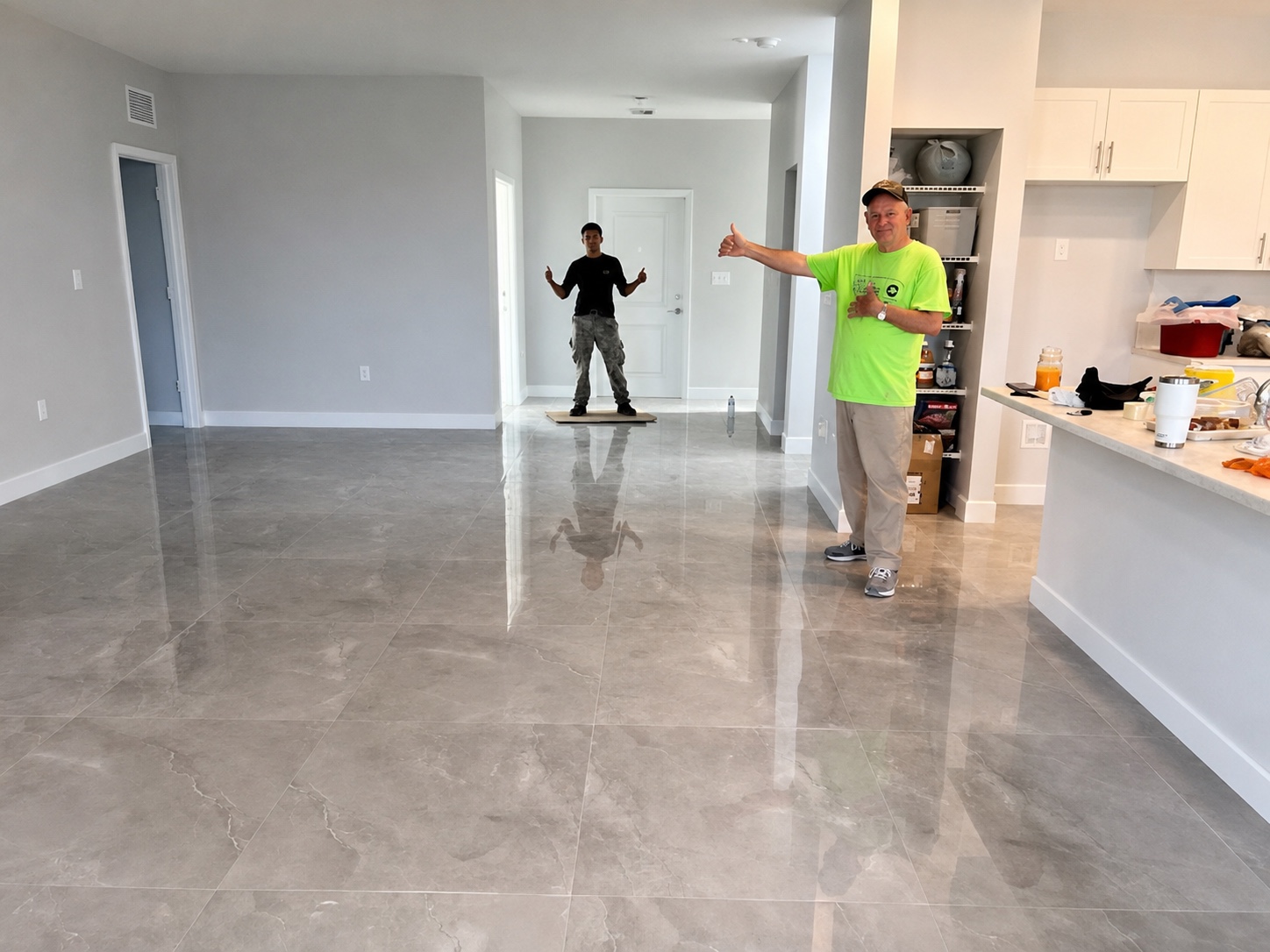 Piso gris brillante con dos personas junto al área de cocina
