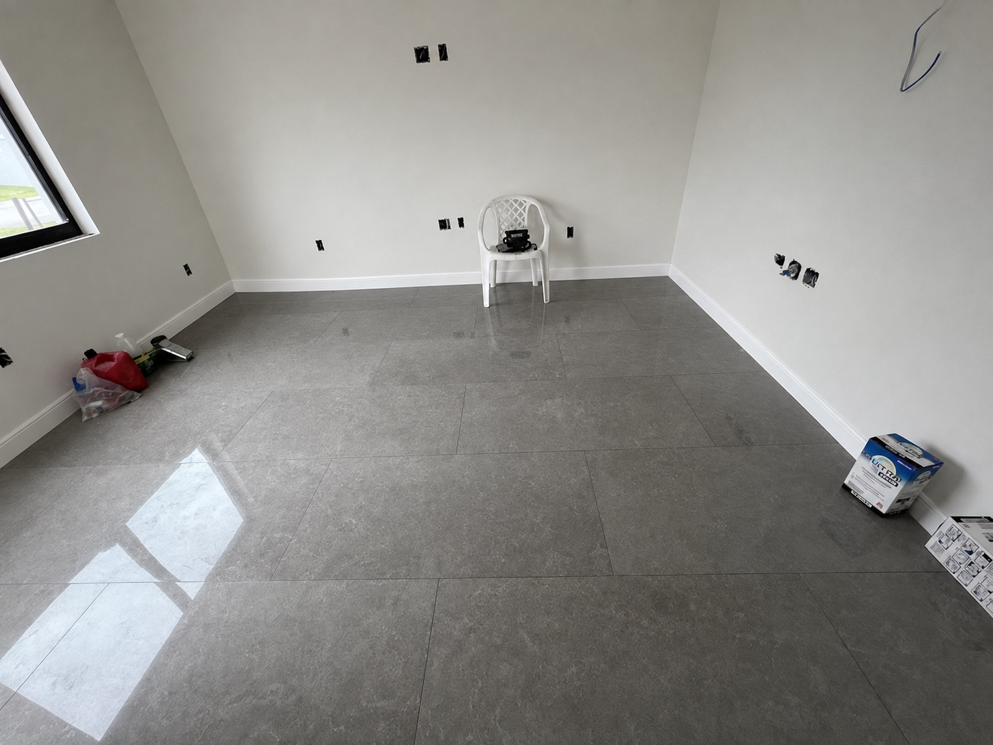 Habitación con piso gris brillante y zócalos blancos