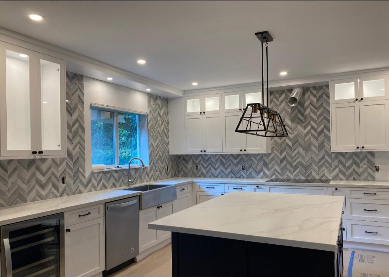 Cocina blanca remodelada con backsplash en diseño espiga
