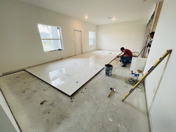 Trabajador instalando piso claro de gran formato en sala