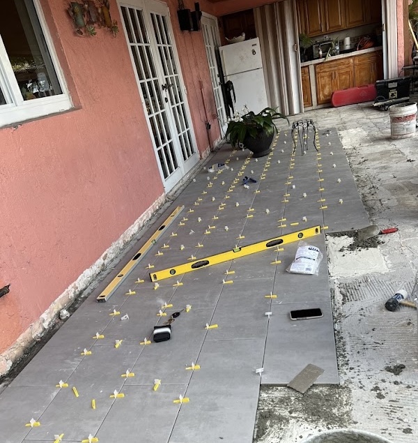 Instalación de piezas grises en patio con separadores y nivel