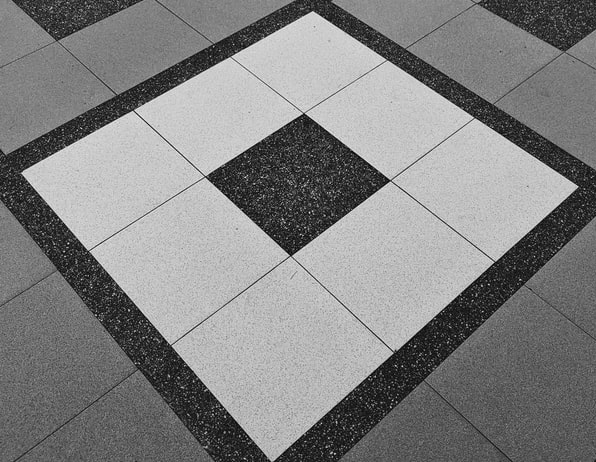 Piso gris blanco y negro con diseño de cuadrados concéntricos