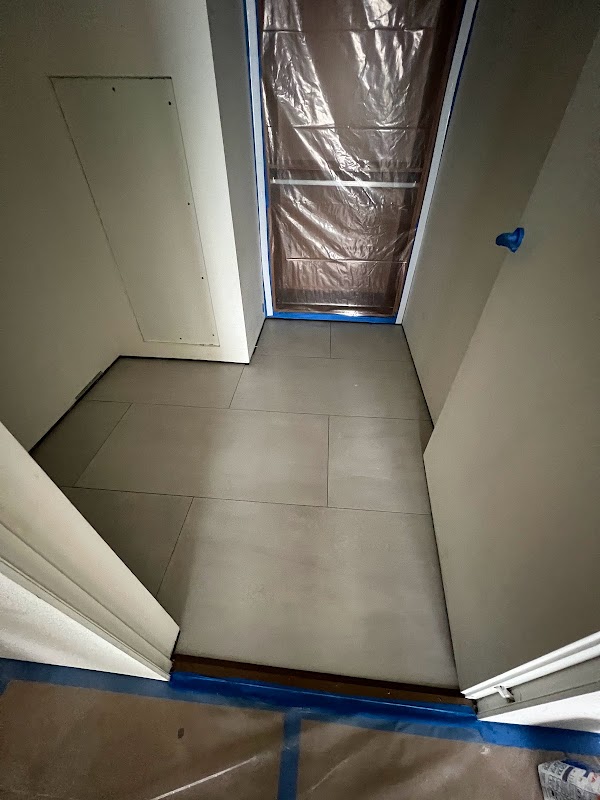 Instalación de piso gris en espacio pequeño con puerta protegida