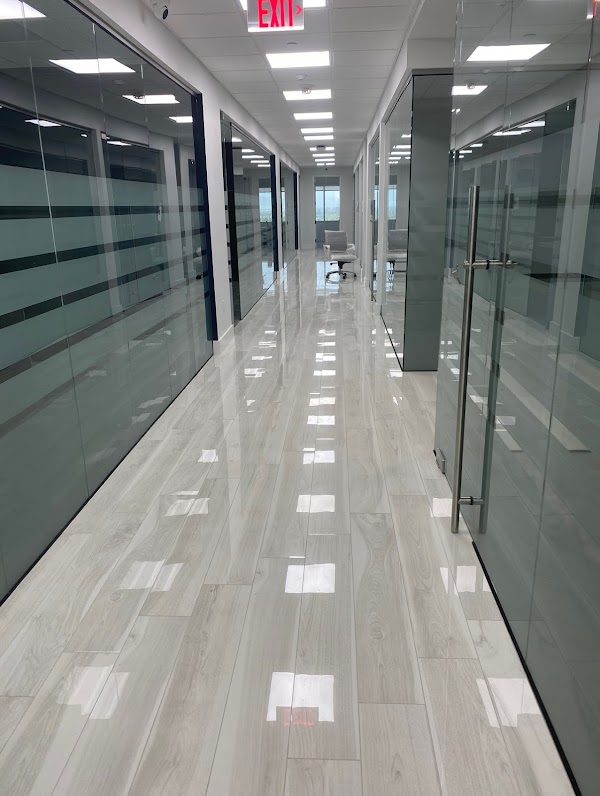 Piso claro de piezas alargadas entre oficinas de cristal