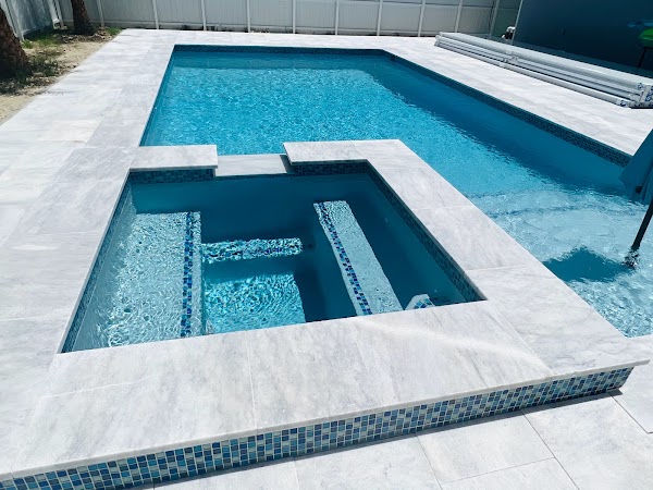 Vista del spa con mosaicos azules y bordes claros junto a piscina