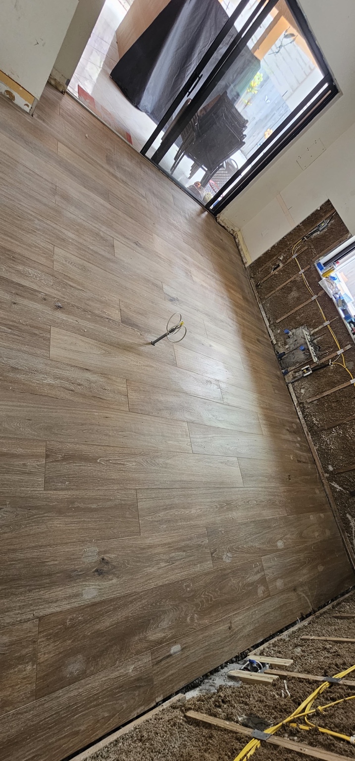 Piso de apariencia madera junto a puerta de cristal durante remodelación interior